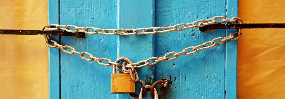 Padlocked chain on blue doors