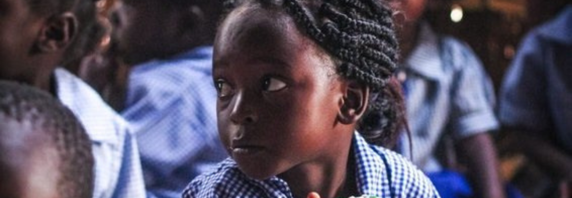 Young girl in school uniform eating lunch