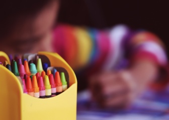 Child coloring with crayons 