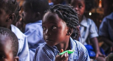 Young girl in school uniform eating lunch