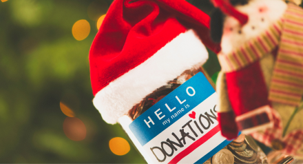 Donations jar in a Christmas hat against green background